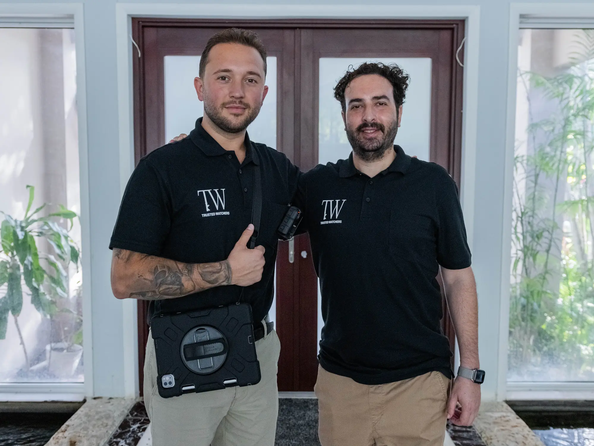 Adam Freshman and Gezim of Trusted Watchers standing together in a residence